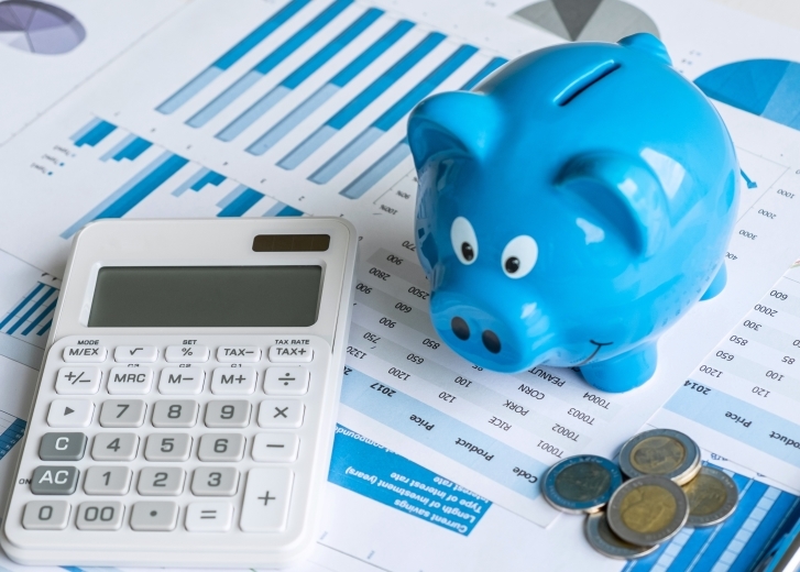 Piggy bank and calculator on financial paperwork