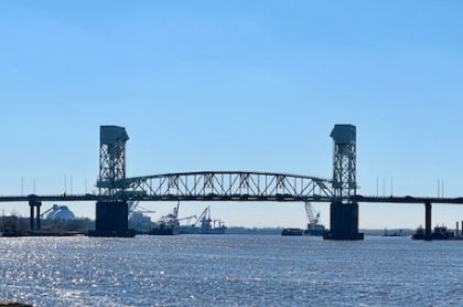 Retired couple with financial adivsor sitting at a desking signing paperwork.