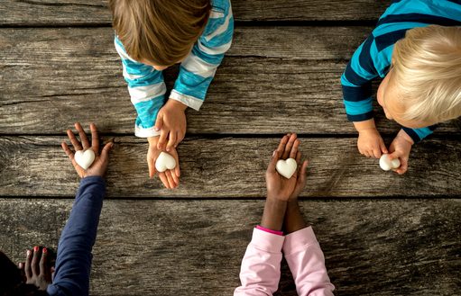 hands holding a blank notebook on a wooden desk
